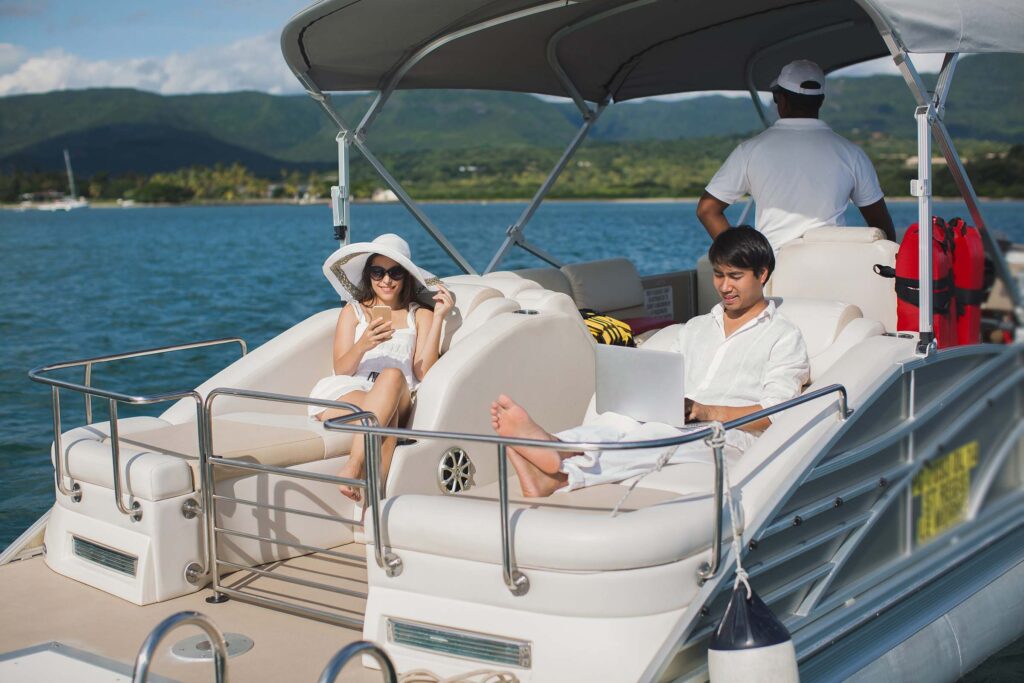 handsome-man-and-woman-on-deck-of-yacht-with-mobil-AMC8676.jpg